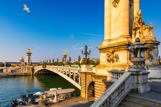 Pont Alexandre III bridge over river Seine in the sunny summer morning. Bridge decorated with ornate Art Nouveau lamps and sculptures. The Alexander III Bridge across Seine river in Paris, France.