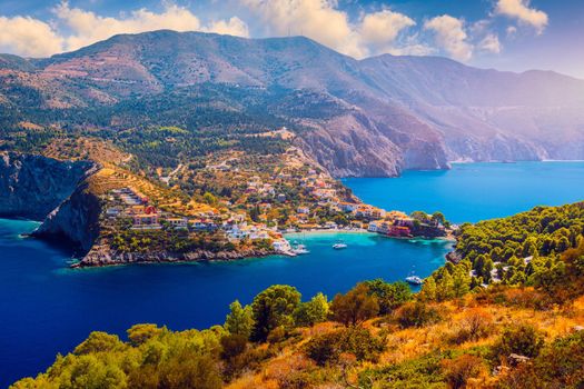 Turquoise colored bay in Mediterranean sea with beautiful colorful houses in Assos village in Kefalonia, Greece. Town of Assos with colorful houses on the mediterranean sea, Greece. 