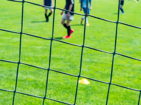 Net of a soccer goal , two teams playing the soccer