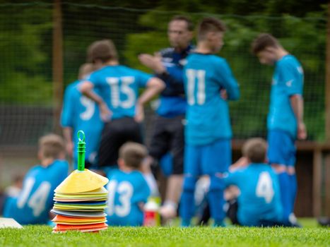 Young football players have meeting with coach within football match