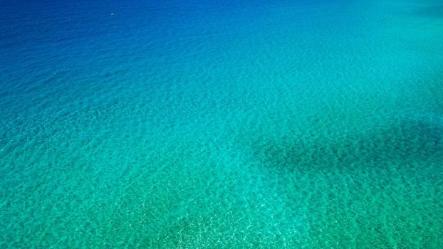 Sea surface aerial view. Background image of the turquoise sea. Deep sea and corals. Aerial drone shot of turquoise water, space for text. Aquamarine background. Sea Aerial view.