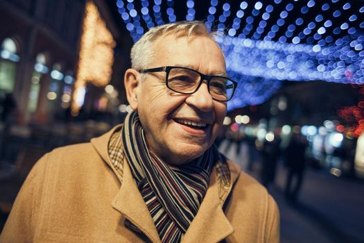 Outdoor portrait of happy senior man in city.