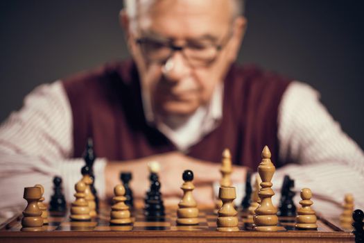 Portrait of senior man who is participating in chess game.