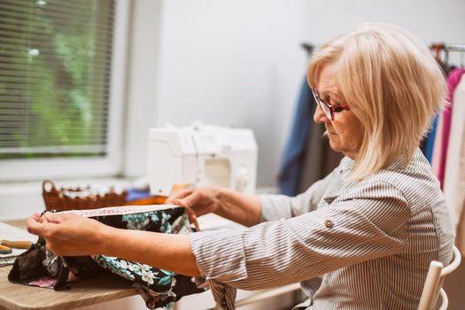 Adult woman is sewing in her studio.