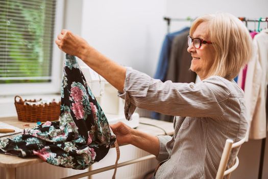 Adult woman is sewing in her studio.