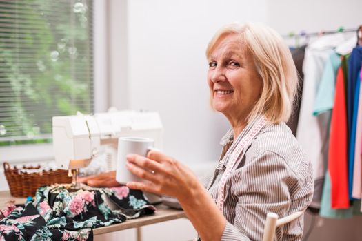 Adult woman is sewing in her studio.