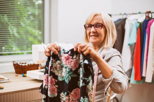 Adult woman is sewing in her studio.