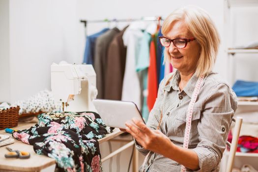 Adult woman is sewing in her studio.