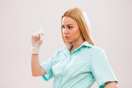 Portrait of young nurse who is holding syringe.