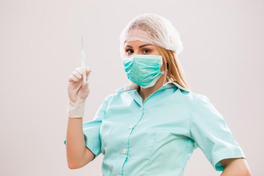 Portrait of young nurse who is holding syringe.