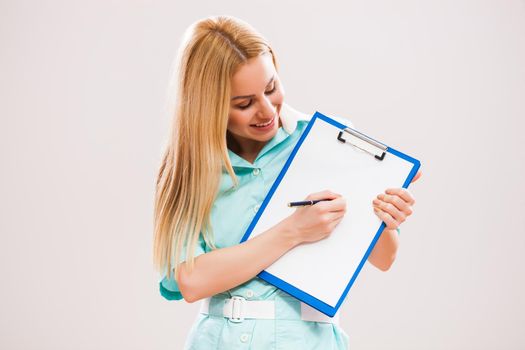 Portrait of young doctor who is writing prescription.