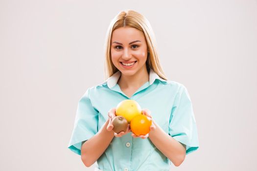 Portrait of young nurse who is holding fruit.