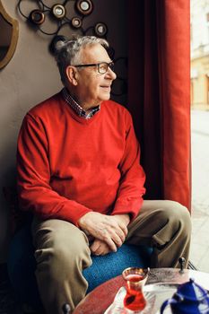 Portrait of happy senior man in a cafe.