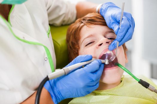 Dentist is repairing teeth of a little boy.