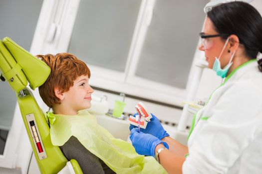 Dentist is teaching little boy about oral hygiene.