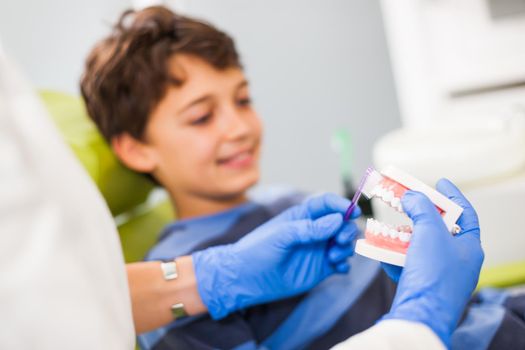 Dentist is teaching little boy about oral hygiene.