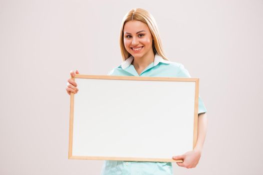 Portrait of young nurse who is holding whiteboard.