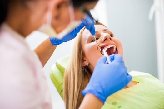 Young woman at dentist. Doctor is injecting anesthetic.
