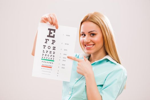 Portrait of young doctor who is holding eye examination test.