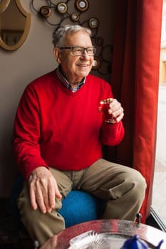 Senior man is drinking tea in a cafe.