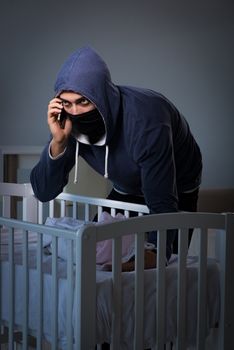 Criminal stealing baby in human child traficking concept