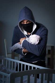 Criminal stealing baby in human child traficking concept