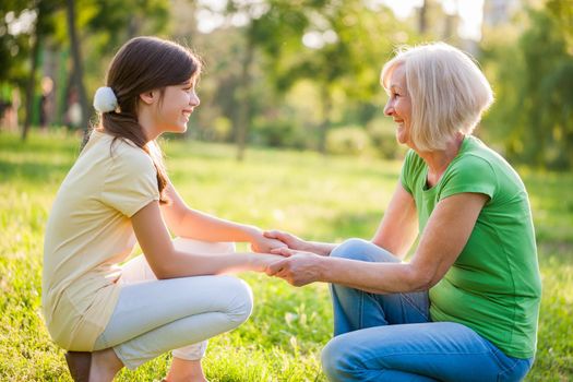 Grandmother and granddaughter are having nice time together in park.