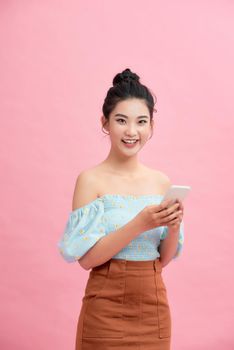 Happy cute beautiful young woman play games by mobile phone on gradient background.