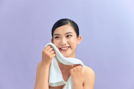 Woman cleaning facial skin with towel after washing face portrait