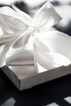 Anniversary celebration, shop sale promotion and luxe surprise concept - Luxury holiday white gift box with silk ribbon and bow on black background, luxe wedding or birthday present