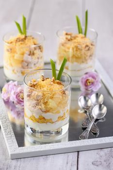 Chicken salad with pineapple, corn, seasoned with Greek yogurt, crushed nuts and grated cheese. A salad in a glass, a great idea for serving food in portions.