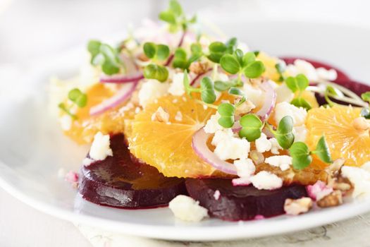 Orange salad with baked beetroot, goat cheese, microgreens and nuts. Perfect as a side dish or as a light lunch for a brunch or dinner.