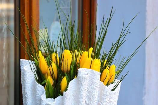 Bouquet of yellow fresh tulips on the window in a vase