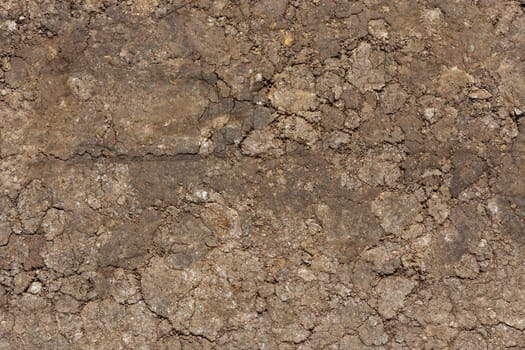 dry rammed bare earth surface under direct sunlight - full frame background and texture.