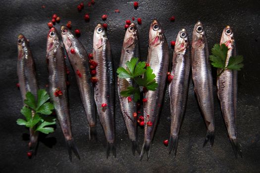 Presenting series anchovy crude above background black stone