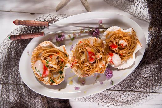 First dish with spaghetti integral to scallops and parsley
