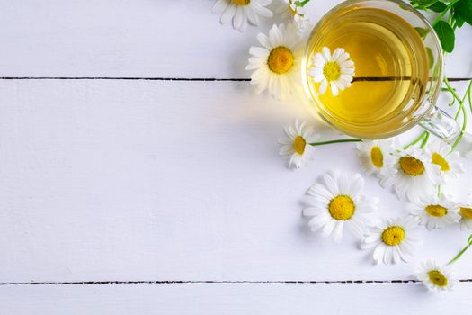 Close-up top view of a cup of chamomile tea and flowers. Alternative and traditional medicine. Herbal treatment. Selective focus. Copy space.