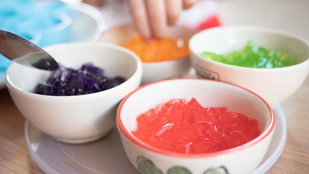 The colored pipo jelly cut into small pieces in a small cup is ready to make desserts for the kids.