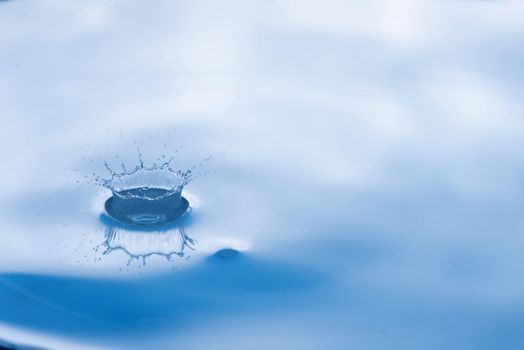 Water drop splash with reflection.