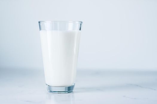 Dairy, healthy nutrition and breakfast concept - World Milk Day, full glass on marble table