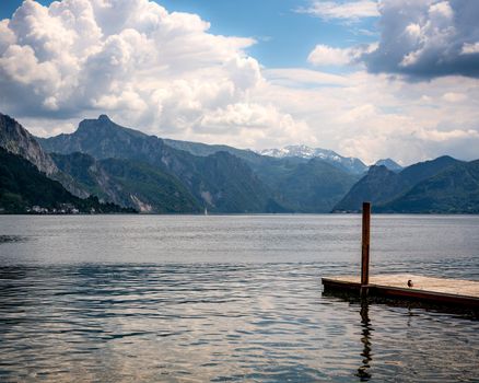 Mountain and Lake view of Traunsee lake, wooden dock and a bird