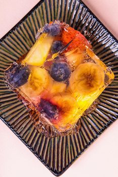 Jelly from different fruits and berries on a square saucer. Dessert. View from above