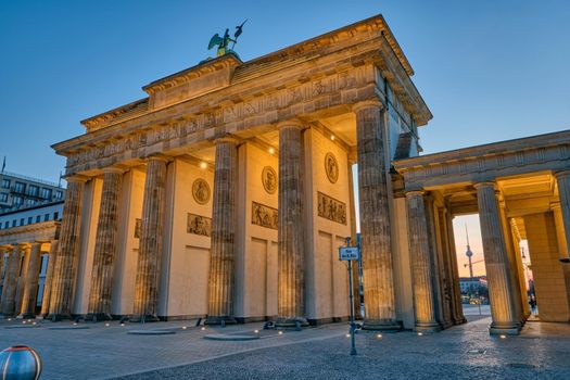 The back side of the famous Brandenburg Gate in Berlin before sunrise with a view to the Television Tower