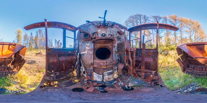 Spherical panoramic photograph of the inside of an old and rusty train locomotive engine room