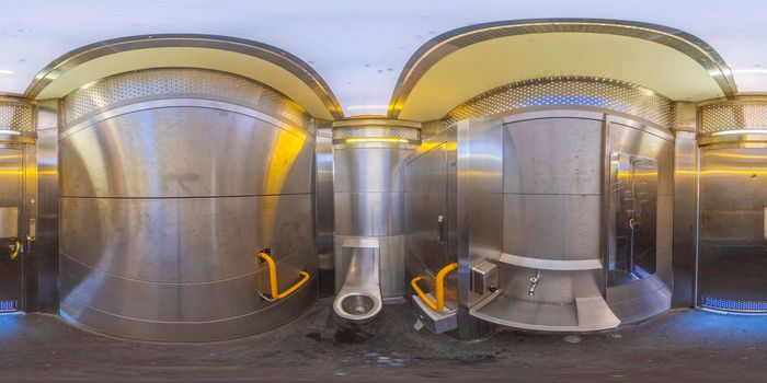 Spherical panoramic photograph of the inside of a general access stainless steel public toilet