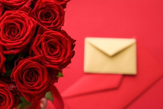 Holiday gift, flowers flatlay and happy relationship concept - Love letter and flower delivery service on Valentines Day, luxury bouquet of red roses and card envelopes on red background