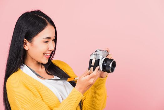 Attractive energetic happy Asian portrait beautiful cute young woman teen excited smiling holding vintage photo camera, studio shot isolated on pink background, traveler female photographer