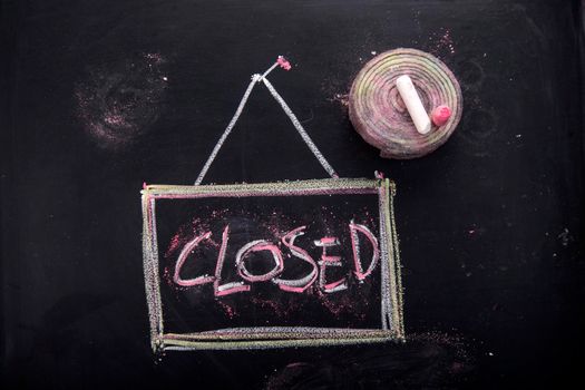 Graphic representation of the word, closed, written with chalk on blackboard