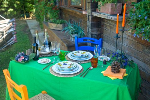 Set table outdoors in rustic setting in summer