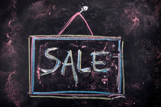 Graphic representation with chalk on blackboard the word sale